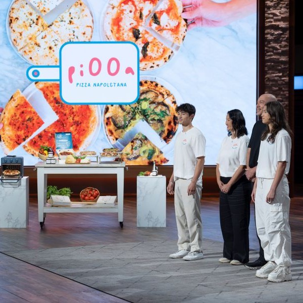 Image of pi00a founders standing on shark tank set pitching idea